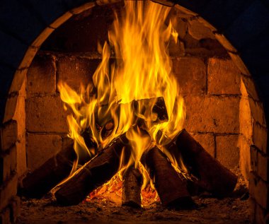 Bir şömine bulunan bir ateş yakar