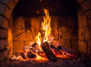 Bir şömine bulunan bir ateş yakar