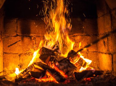 Bir şömine bulunan bir ateş yakar