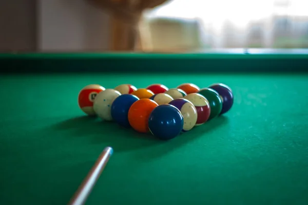 Billiard balls on green table with billiard cue in a hotel hall — Stock Photo, Image