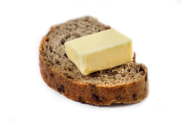Pan de centeno oscuro con semillas y mantequilla sobre fondo blanco —  Fotos de Stock