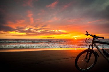 Turist Bisiklet günbatımı zaman Denizi'nin kıyısında