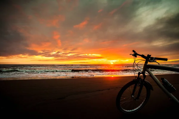 Bicicleta turística na costa do mar ao pôr do sol — Fotografia de Stock