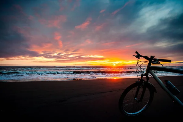 Touristenfahrrad an der Küste des Meeres bei Sonnenuntergang — Stockfoto