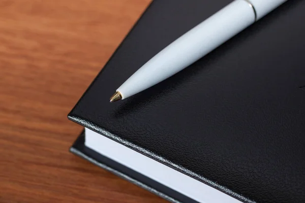 Schwarzes Tagebuch oder Skizzenbuch mit Stift und Bleistift auf dem Tisch — Stockfoto