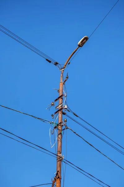 Щогла електричної лінії живлення проти блакитного неба — стокове фото