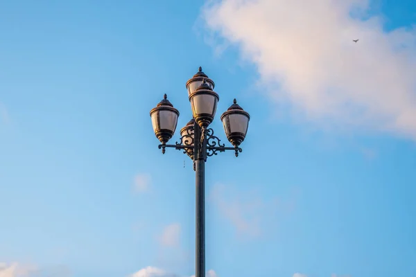 De oude retro lantaarnpaal en de mooie witte en blauwe hemel — Stockfoto