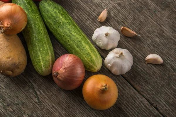 Alho, cebola, pepino, batatas e tomate em uma mesa velha — Fotografia de Stock