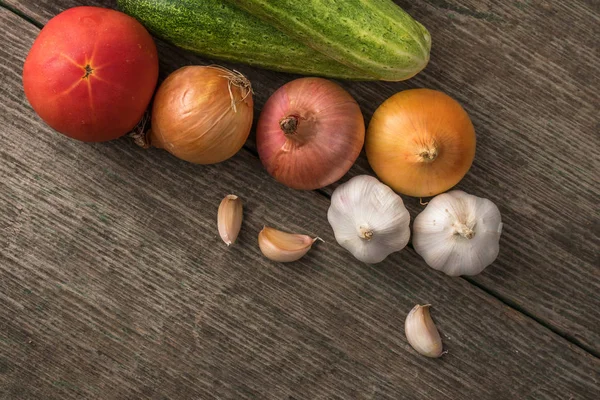 Alho, cebola, pepino, batatas e tomate em uma mesa velha — Fotografia de Stock