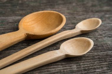 El yapımı tahta kaşıklar ahşap bir masa, mutfak araçları üzerinde