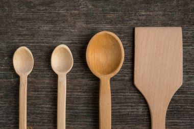 El yapımı tahta kaşıklar ahşap bir masa, mutfak araçları üzerinde