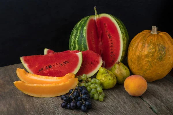 Vattenmelon, melon, vindruvor, persika, päron, pumpa på gamla trähus ta — Stockfoto