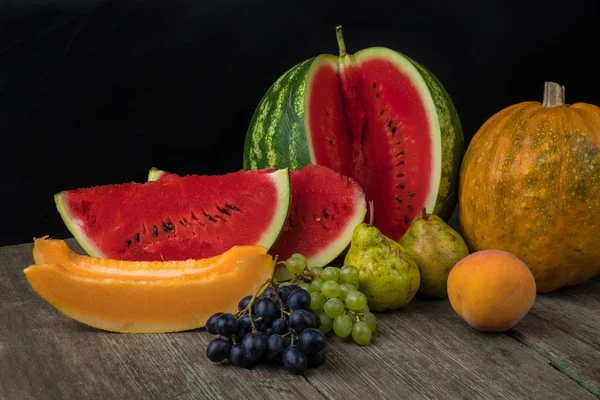 Vattenmelon, melon, vindruvor, persika, päron, pumpa på gamla trähus ta — Stockfoto