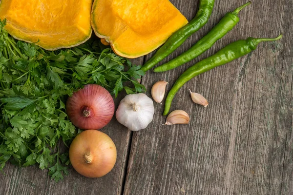 Cebola, abóbora, alho, pimenta, coentro e salsa em um velho — Fotografia de Stock