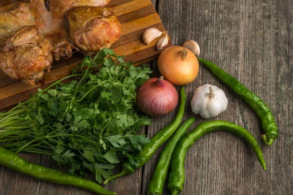 Frango frito e legumes em uma velha tábua de madeira — Fotografia de Stock