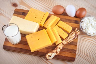 yumurta ile ahşap bir tahta üzerinde peynir ve süt ürünleri