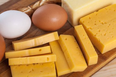 yumurta ile ahşap bir tahta üzerinde peynir ve süt ürünleri