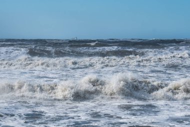 Fırtınalı denizde büyük dalgalar sahile kırma
