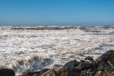 Fırtınalı denizde büyük dalgalar sahile kırma