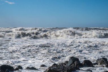 Fırtınalı denizde büyük dalgalar sahile kırma