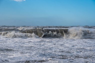 Fırtınalı denizde büyük dalgalar sahile kırma