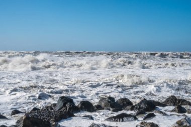 Fırtınalı denizde büyük dalgalar sahile kırma