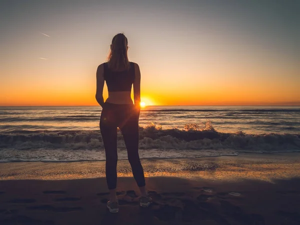 Ragazza sul mare durante il tramonto. Fitness e stile di vita sano — Foto Stock