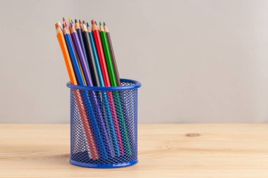 Gri zemin üzerine mavi kutu içinde renkli kalemler