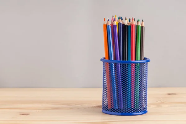 Colored pencils in the blue box on gray background — Stock Photo, Image