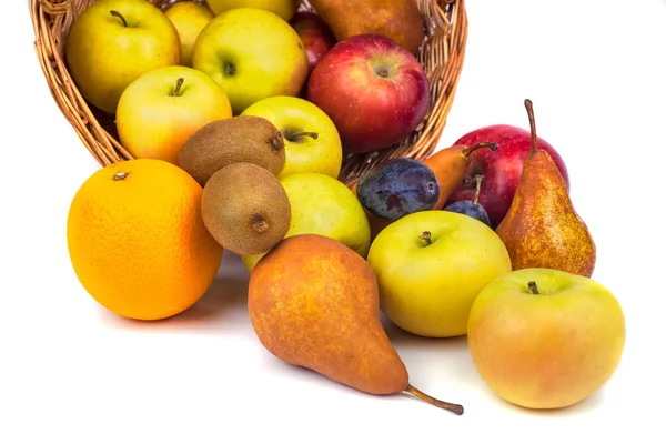 Maçãs e outras frutas em uma cesta de vime em um fundo branco — Fotografia de Stock