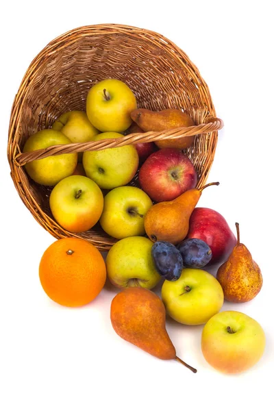 Maçãs e outras frutas em uma cesta de vime em um fundo branco — Fotografia de Stock
