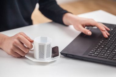 Kadın tipik küçük fincan beyaz kahve ile klavye üzerinde beyaz t