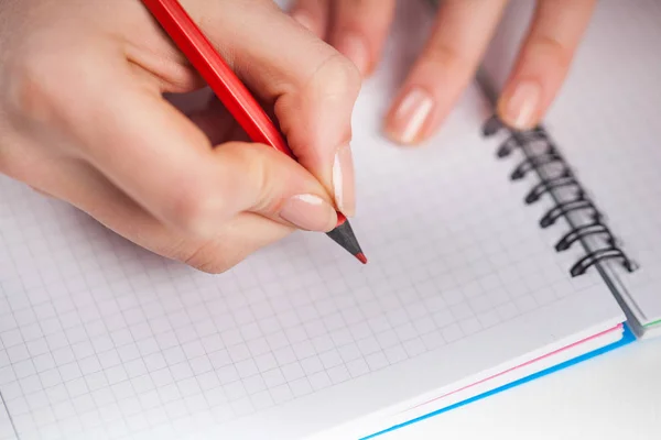 Mãos de mulher jovem segurar abriu páginas caderno com lápis vermelho — Fotografia de Stock