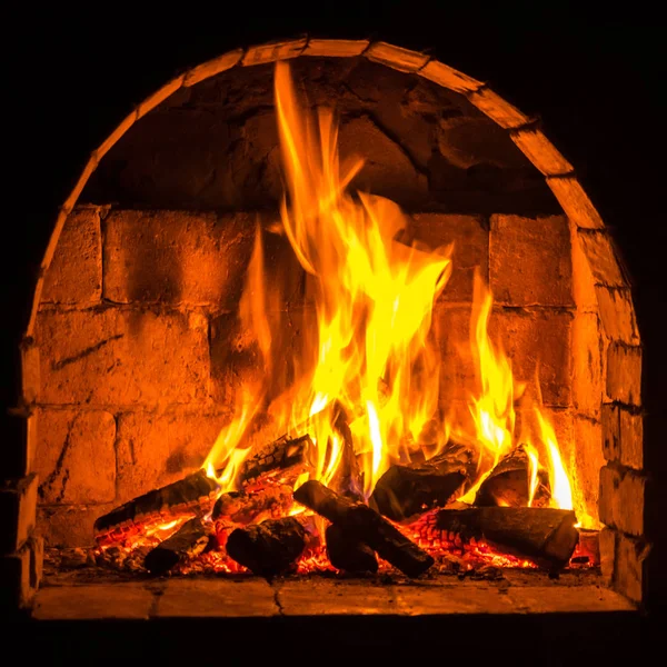 Μια φωτιά καίει σε ένα τζάκι, φωτιά για να κρατήσει ζεστό — Φωτογραφία Αρχείου