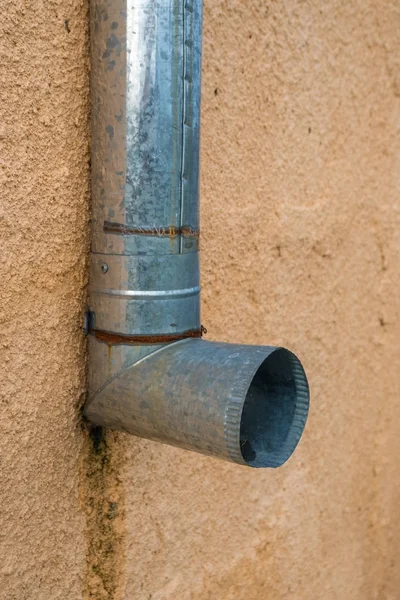 Vecchio tubo di scarico in metallo su una parete arancione — Foto Stock