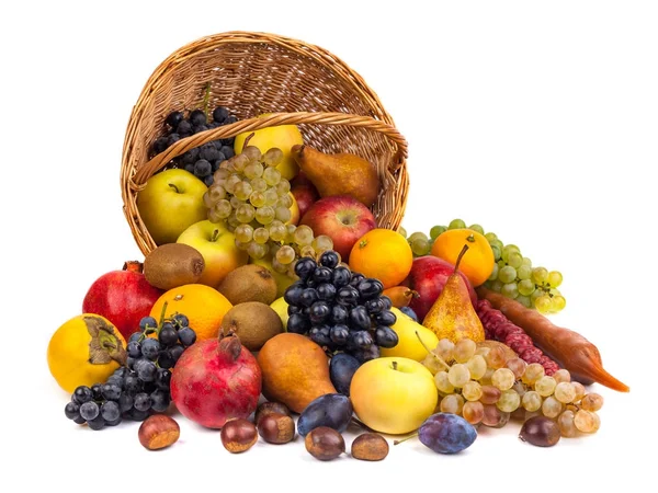 Maçãs e outras frutas em uma cesta de vime em um fundo branco — Fotografia de Stock