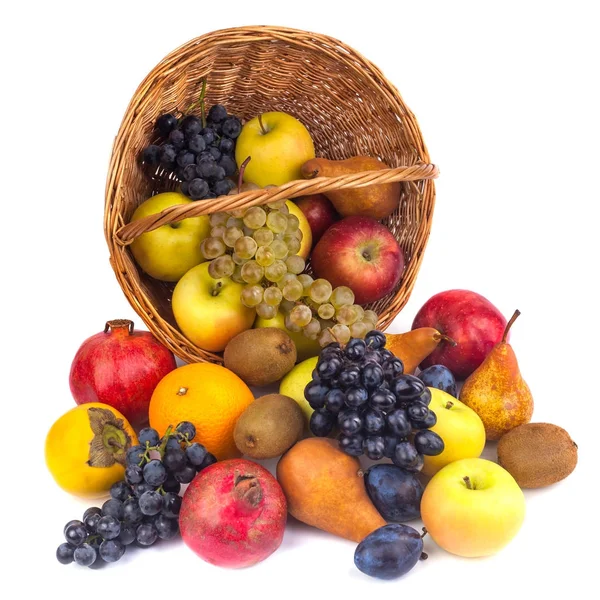 Maçãs e outras frutas em uma cesta de vime em um fundo branco — Fotografia de Stock