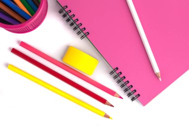 sepet, silgi ve beyaz arka üstünde defter renkli kalemler