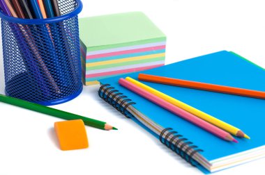 sepet, silgi ve beyaz arka üstünde defter renkli kalemler