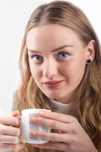 A atraente menina de olhos azuis com uma xícara de perto — Fotografia de Stock