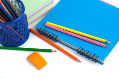 sepet, silgi ve beyaz arka üstünde defter renkli kalemler