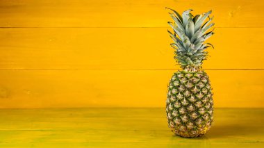 Sarı ahşap arka planda olgun ananas.