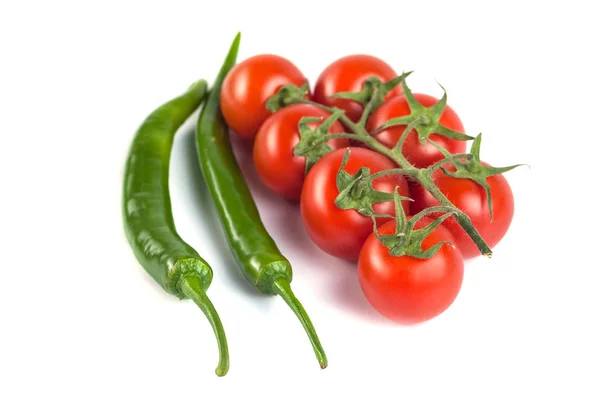 Tomates e pimentas verdes sobre um fundo branco — Fotografia de Stock