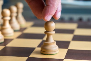 Bir satranç tahtası üzerinde beyaz bir piyon hareket el