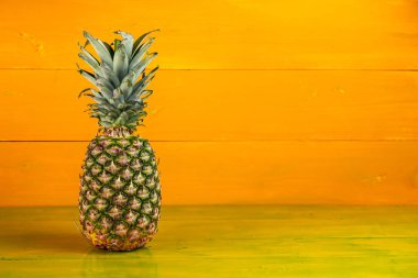 Sarı ahşap arka planda olgun ananas.