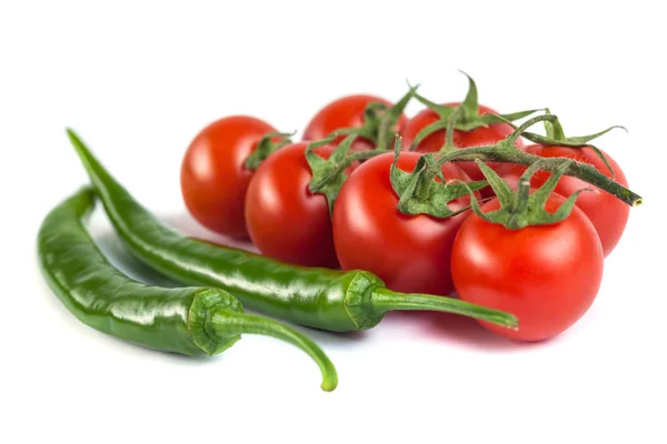 Tomates e pimentas verdes sobre um fundo branco — Fotografia de Stock