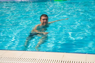 Genç adam portresi Açık Yüzme havuzunda rahatlatıcı, yaz 