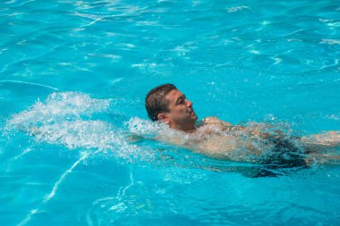 Genç adam portresi Açık Yüzme havuzunda rahatlatıcı, yaz 