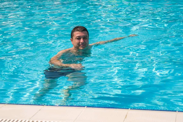 Retrato de hombre joven relajándose en la piscina, verano al aire libre — Foto de Stock