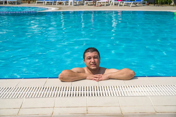 Retrato de hombre joven relajándose en la piscina, verano al aire libre — Foto de Stock